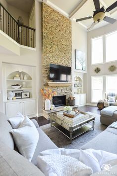 a living room filled with furniture and a fire place in front of a stone wall