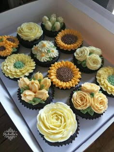 cupcakes decorated with yellow and white flowers in a box