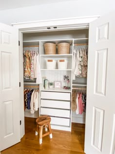 an open closet with clothes and baskets on the shelves, next to a step stool