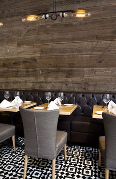 a restaurant with wooden walls and leather booths