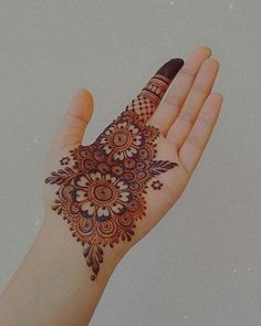 a person's hand with a henna on it and an intricate design in the middle