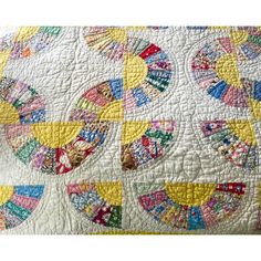 the quilt is made up and has many different designs on it, including circles in bright colors