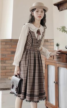 Plaid pinafore dress with a v-neckline, button down front, belted waist and midi skirt with black lace trims. Concealed side zipper. Matching blouse available with a peter pan collar, lace trims and neck detail. BlouseS: 14.5” across shoulders, 35" chest, 22" lengthM: 15” across shoulders, 36.5" chest, 22" lengthL: 15.5” across shoulders, 38" chest, 22.5" lengthXL: 16” across shoulders, 39.5" chest, 22.5" length DressS: 26" waist, 39.5" lengthM: 27.5" waist, 39.5" lengthL: 29" waist, 40" lengthXL: 30.5" waist, 40" length Midi Dress Brown, Cottagecore Fashion, Lace Trims, Pinafore Dress, Brown Dress, Overall Dress, Pan Collar, Clothing Ideas, Korean Outfits