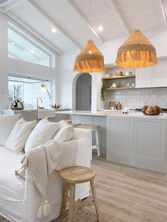 a living room filled with white furniture and lots of lights hanging from it's ceiling