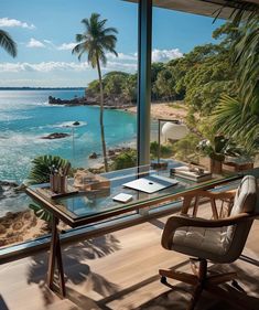 a desk with a view of the ocean and palm trees in front of an open window