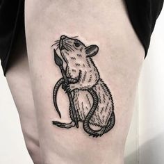 a small rat tattoo on the leg