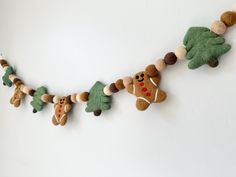 a garland made out of felt with teddy bears and christmas trees hanging from it's sides