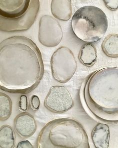 several different types of plates and spoons on a white tablecloth with silver foil