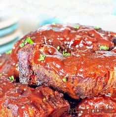 a plate with ribs covered in bbq sauce and garnished with parsley