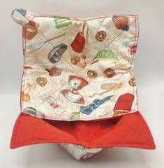 a red and white cloth bag with an orange lining on the bottom that has images of different objects printed on it