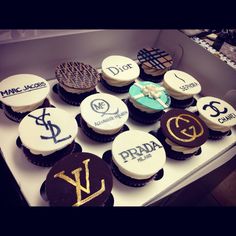 twelve cupcakes are arranged in a box with the names of different brands on them