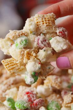 a hand holding up a piece of candy cornflakes with white and green sprinkles