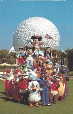 a group of people standing next to each other in front of a large ball shaped structure