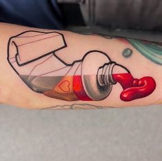 a person with a tattoo on their arm has a red liquid pouring out of a bottle