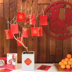 a table topped with cards and oranges on top of a white table next to a tree