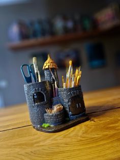 a desk with some pens and pencils in it on top of a wooden table