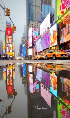 a city street filled with lots of tall buildings and billboards on the side of it