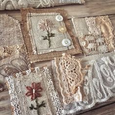 several pieces of lace and buttons are laid out on a wooden surface, some with flowers in them