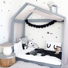 a dog laying on top of a bed in a room with white walls and stars