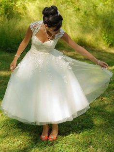 a woman in a white dress is walking through the grass