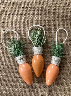 three ceramic carrots tied with twine and some green sprigs on burlap