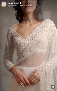 a woman wearing a white dress and jewelry