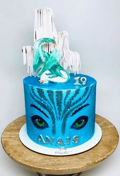 a blue cake decorated with an image of a mermaid and the words anais on it