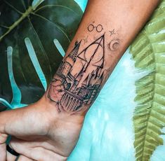 a person with a tattoo on their arm holding onto a hand that has a hogwarts castle on it