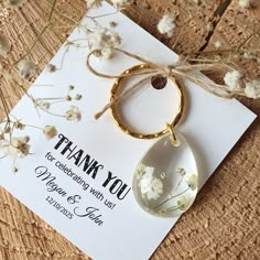 a thank you card with a tear shaped glass ornament attached to the front