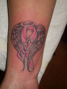 a pink ribbon and angel wings tattoo on the arm