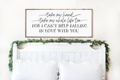 a white bed topped with pillows next to a wooden sign that says, an irish blessing