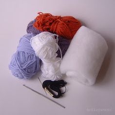 yarn and knitting needles laid out on a white surface