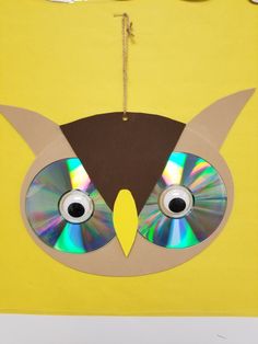 an owl made out of cd's on a yellow background