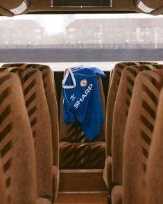 a blue jersey is hanging on the back of a bus with seats in front of it