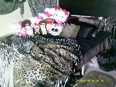 a bed covered in lots of stuffed animals on top of it's covers and pillows