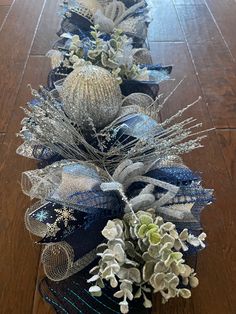 a long row of blue and silver ribbons with flowers on them sitting on a wooden floor