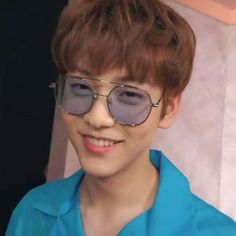 a young man wearing sunglasses and smiling at the camera