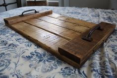 a wooden tray sitting on top of a bed