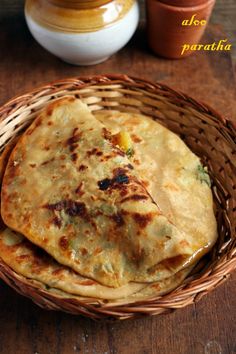 two flat breads in a wicker basket on a wooden table