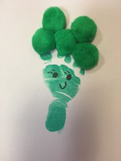 a green handprint with three pom - poms on it and the shape of a caterpillar