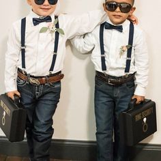 two young boys wearing sunglasses and suspenders, holding briefcases in front of them