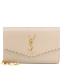 Suited for day-to-night styles, this beige Uptown clutch from Saint Laurent will lend any look a touch of Parisian glamour. It's crafted in Italy from grained calf leather and works an envelope silhouette with the monogram logo in glossy golden hardware. Carry yours in-hand or swing it from the adjustable shoulder strap. | Saint Laurent Uptown Small leather clutch Parisian Glamour, Prom Clutch, Beige Handbags, Leggings Outfit, Best Wallet, Fashion Night, Saint Laurent Bag, Everyday Bag, Monogram Logo