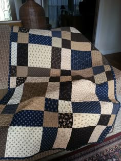 a large blue and brown quilt on top of a couch