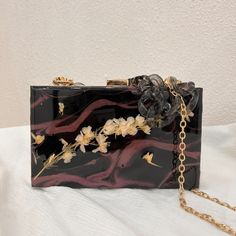 This beautiful handmade clutch is a fashion purse made out of resin. It will definitely be a conversation piece that people will notice! It is an amazing gift for someone in your heart!Highest-quality resins pigmentsExcellent birthday gift, wedding, and teacher appreciation gifts!All items are handmade and may or may not include minor imperfections such as surface irregularities, specs, or bubbles.Cleaning instructions: Use a soft microfiber cloth. You can also use a warm, damp cloth.DO NOT WASH IN THE DISHWASHER. Chic Square Clutch For Gift, Chic Rectangular Clutch As Gift, Chic Rectangular Clutch As A Gift, Chic Rectangular Clutch Perfect As A Gift, Unique Rectangular Party Bags, Black Clutch As A Gift, Chic Brown Clutch For Gift, Chic Brown Clutch As Gift, Handmade Square Clutch As Gift