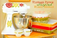 a mixer sitting on top of a wooden table next to bowls and cups with the words vintage prex inspired mixer decals above it