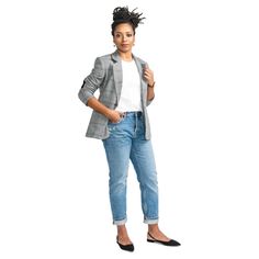 a woman standing in front of a white background wearing jeans and a blazer jacket