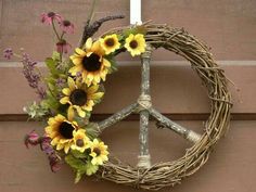 a peace sign made out of branches with sunflowers