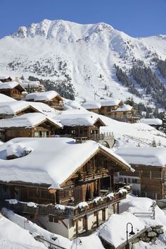 a ski resort with snow covered mountains in the background