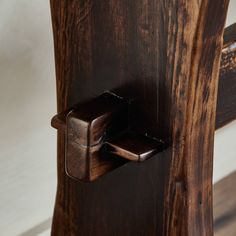 a wooden chair with a metal hook on it's backrest and wood grained seat