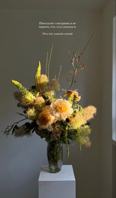 a vase filled with flowers sitting on top of a white pedestal